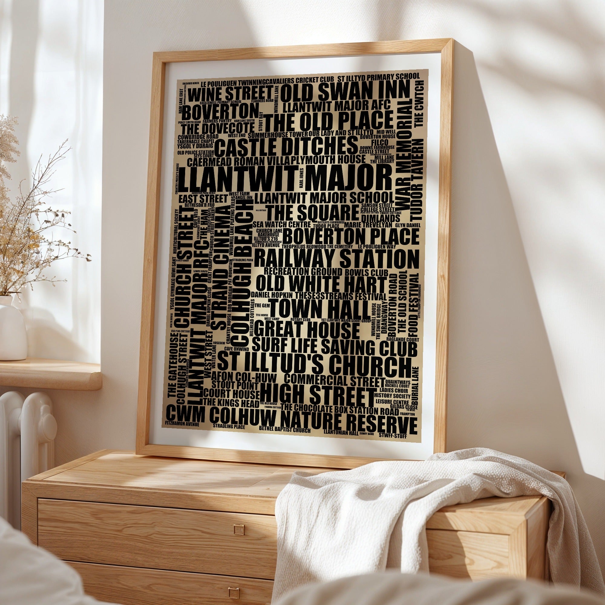 Llantwit Major word art print in a brass frame by a window, rustic portrait poster of 149 real Llantwit Major places including Colhugh Beach and Town Hall