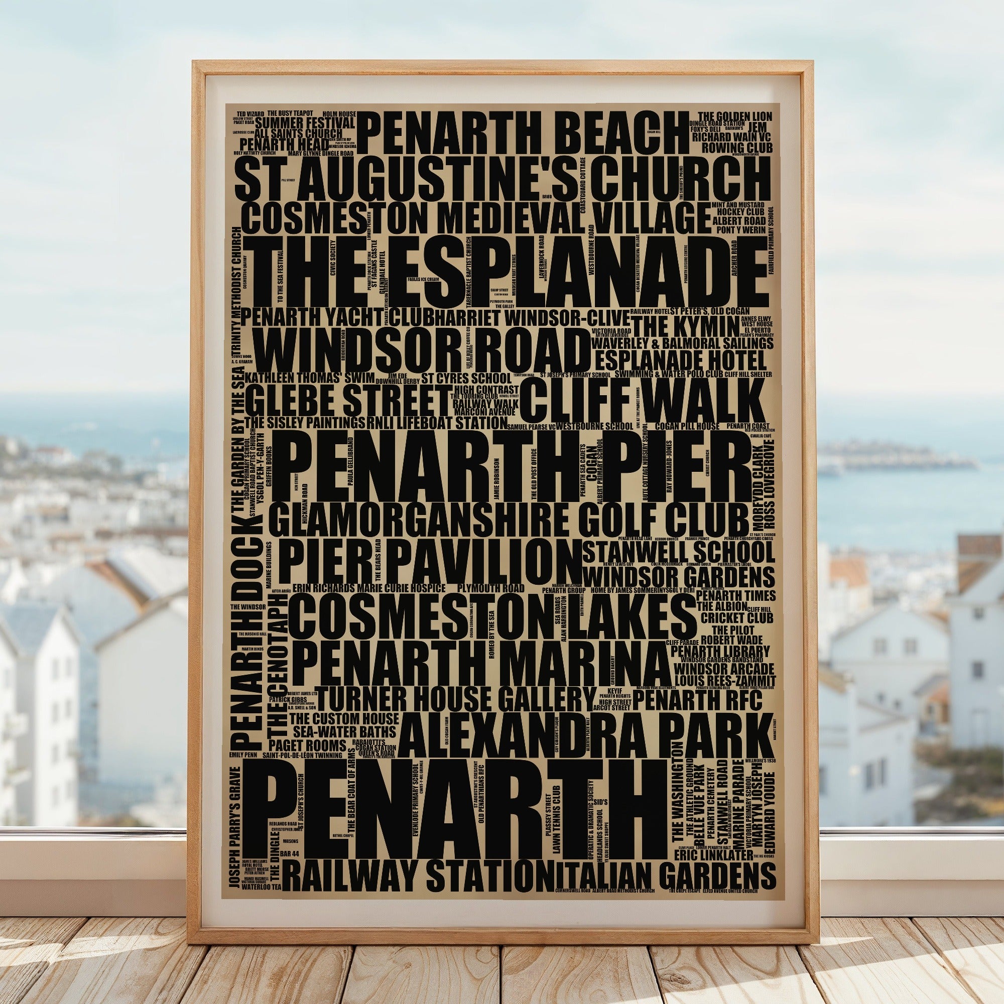 Penarth word art print in a brass frame by a window, rustic portrait poster of 243 real Penarth places including Penarth Pier and Penarth Marina
