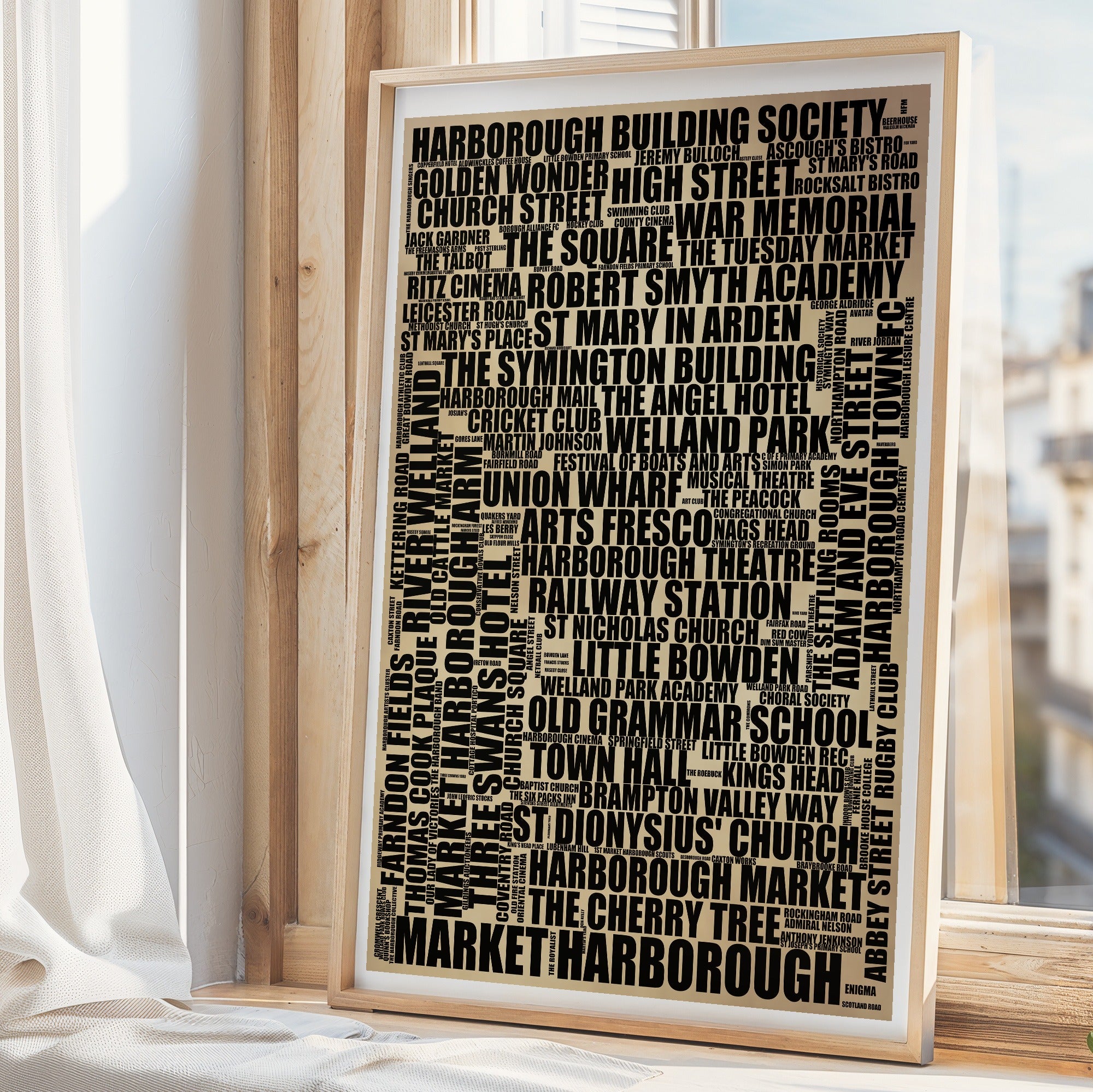 Market Harborough word art print in a brass frame by a window, rustic portrait poster of 169 real Market Harborough places including Old Grammar School and Harborough Market