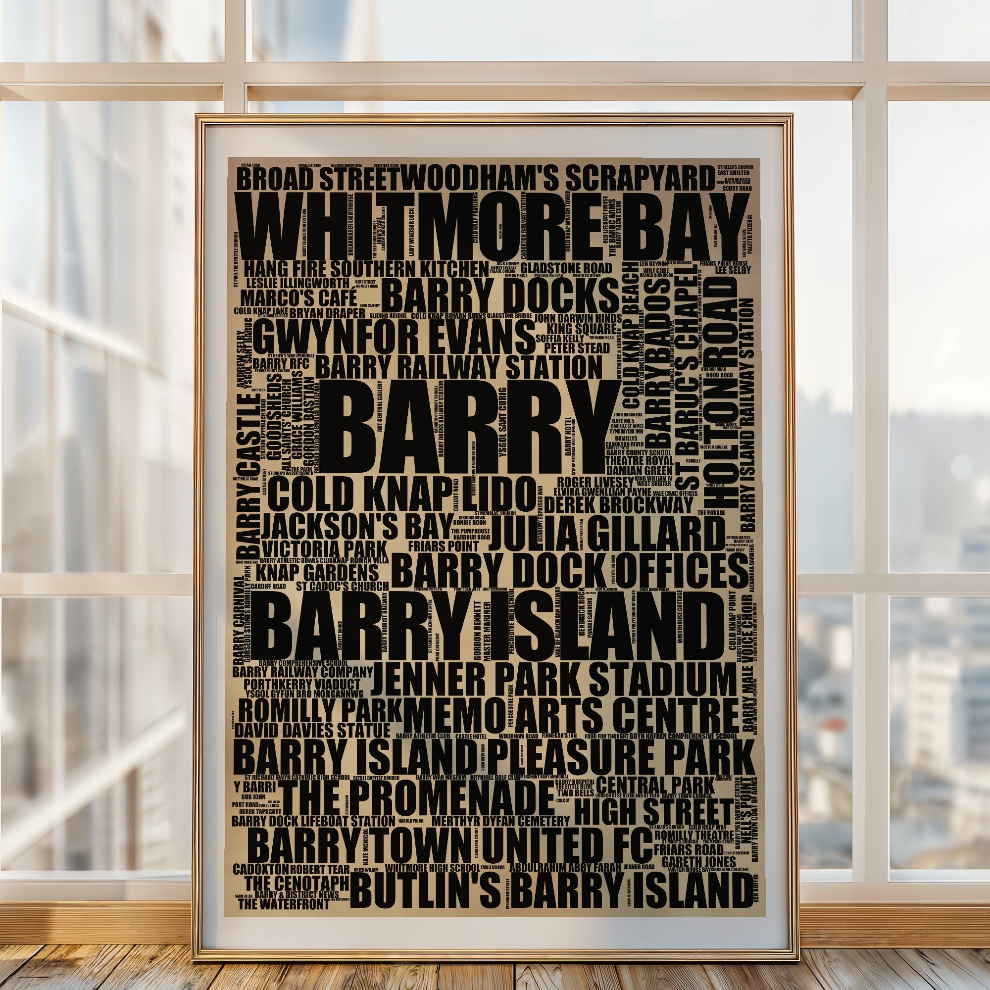 Barry word art print in a brass frame by a window, rustic portrait poster of 250 real Barry places including Whitmore Bay and Barry Docks