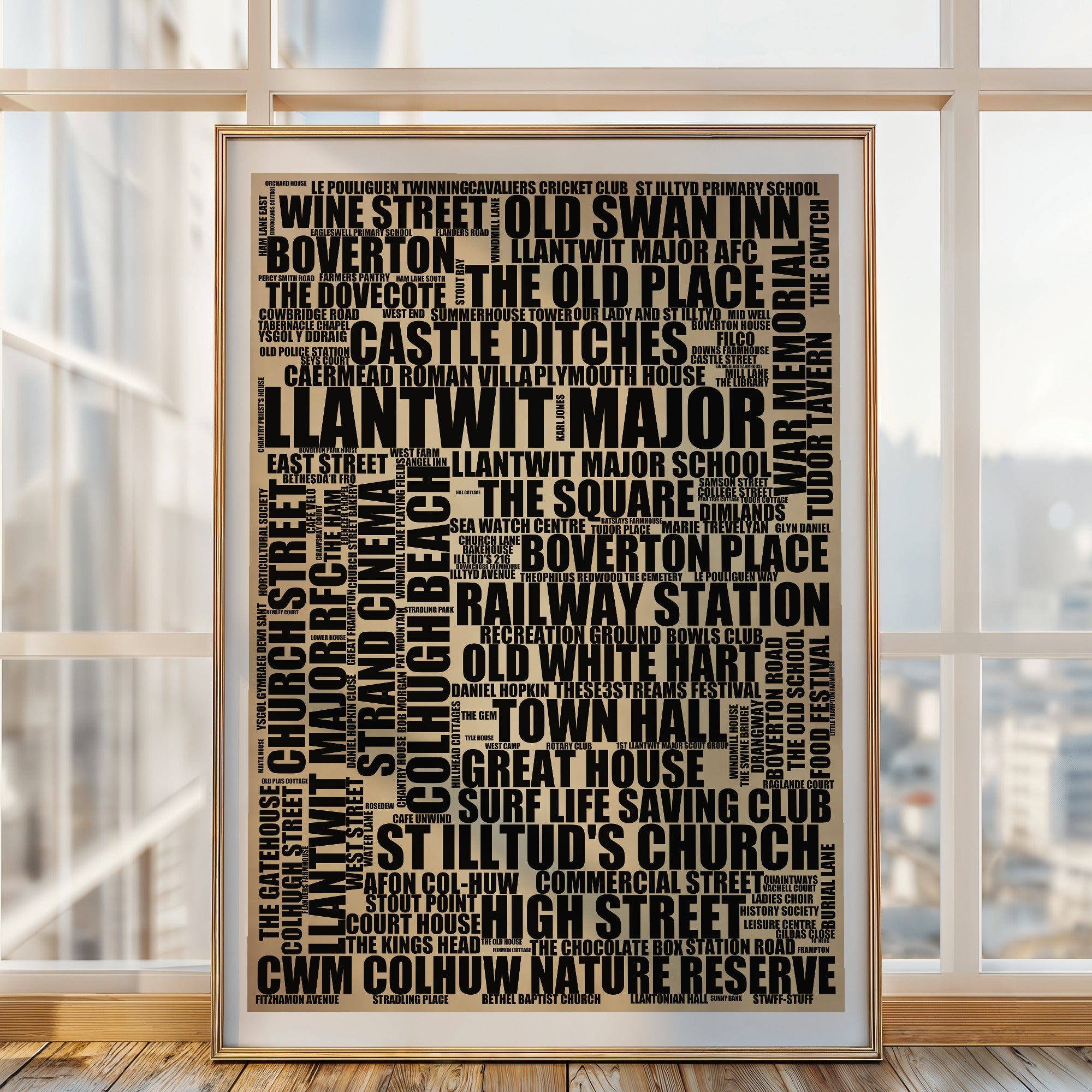 Llantwit Major word art print in a brass frame by a window, rustic portrait poster of 149 real Llantwit Major places including Colhugh Beach and Town Hall